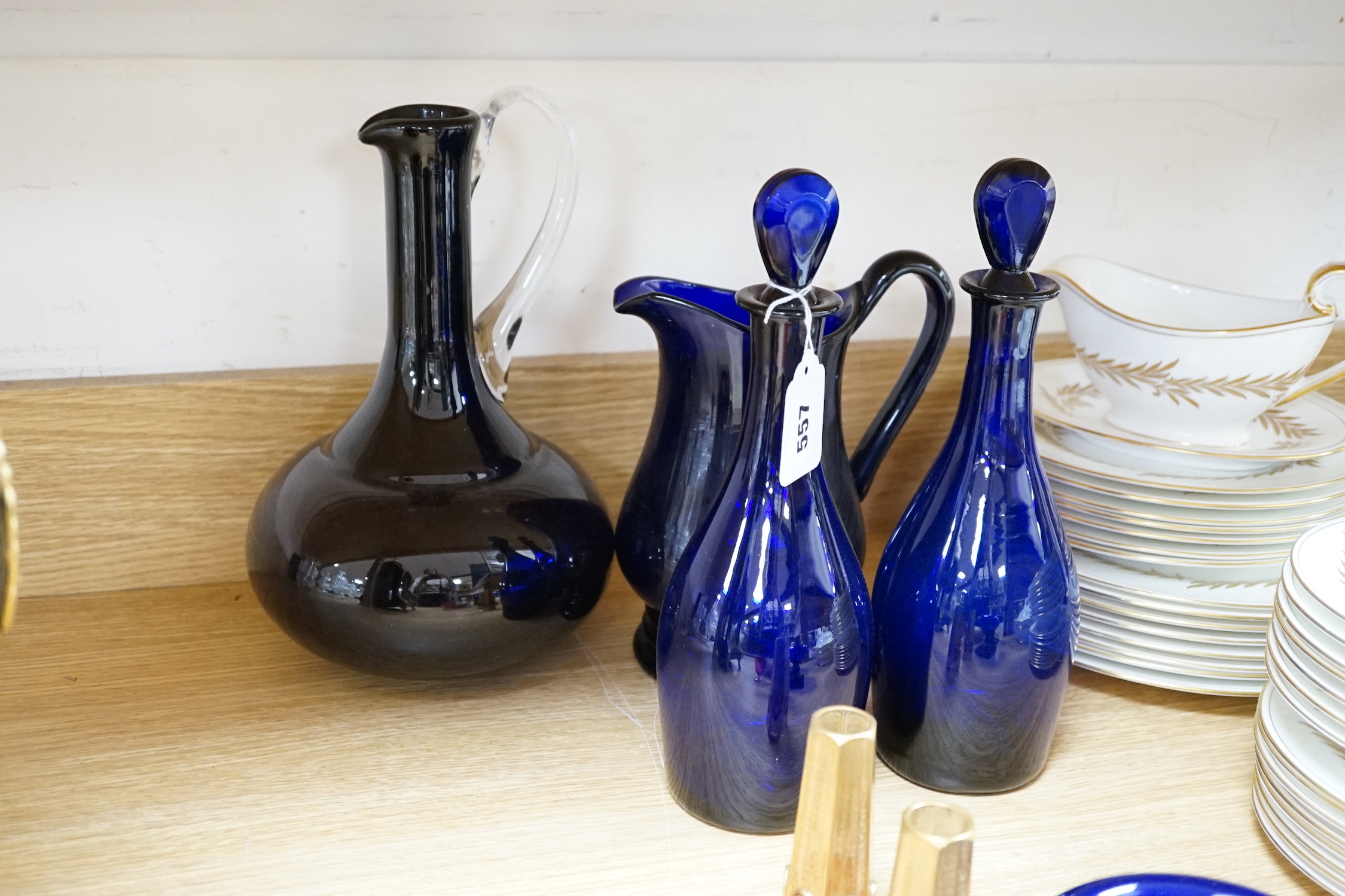 A collection of Bristol blue glassware and other coloured glass including two blue glass decanters, a cranberry, cut glass, decanter, three jugs, pedestal bowls, plates, a pair of miniature vases, etc., tallest 39.5cm (2
